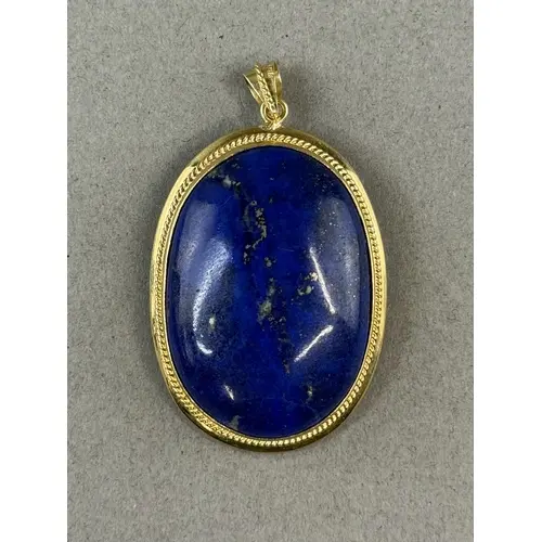 Jewellery: a lapis lazuli pendant, mounted in yellow metal w...