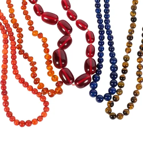 A selection of natural and synthetic necklaces, including la...