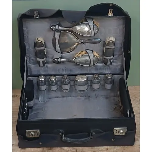 An early 20th century leather case, the interior fitted with...