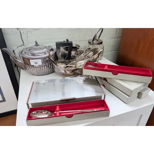 A three piece plated tea set together assorted tea spoons an...