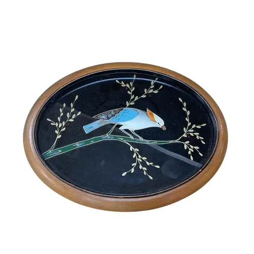 An abalone shell-inlaid oval panel depicting a bird among fl...