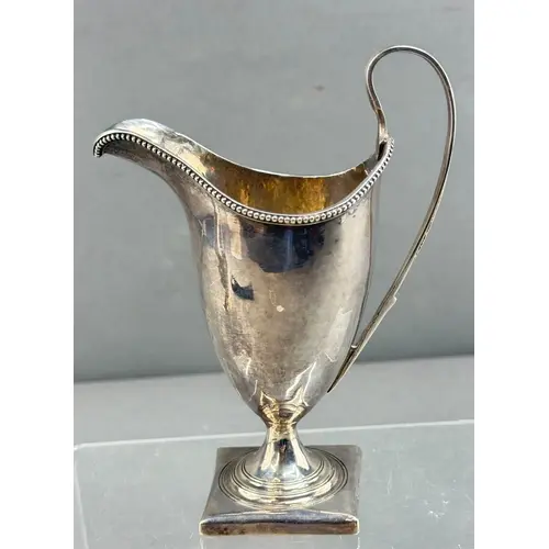 Silver: a George III cream jug of helmet form marked for Geo...