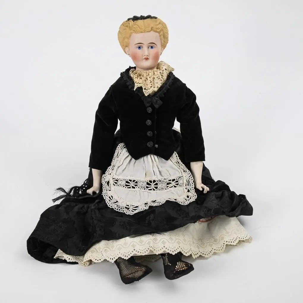 Bust doll wearing black clothing and an apron.