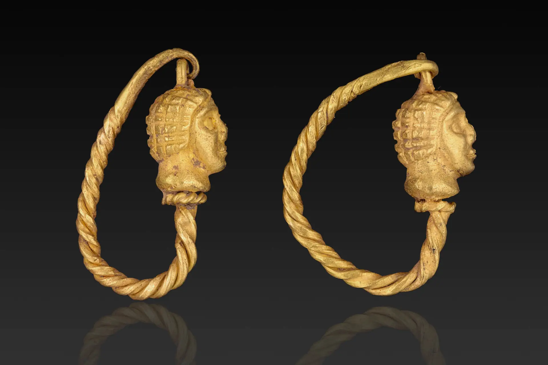 MATCHED PAIR OF HELLENISTIC GOLD EARRINGS WITH MALE HEADS