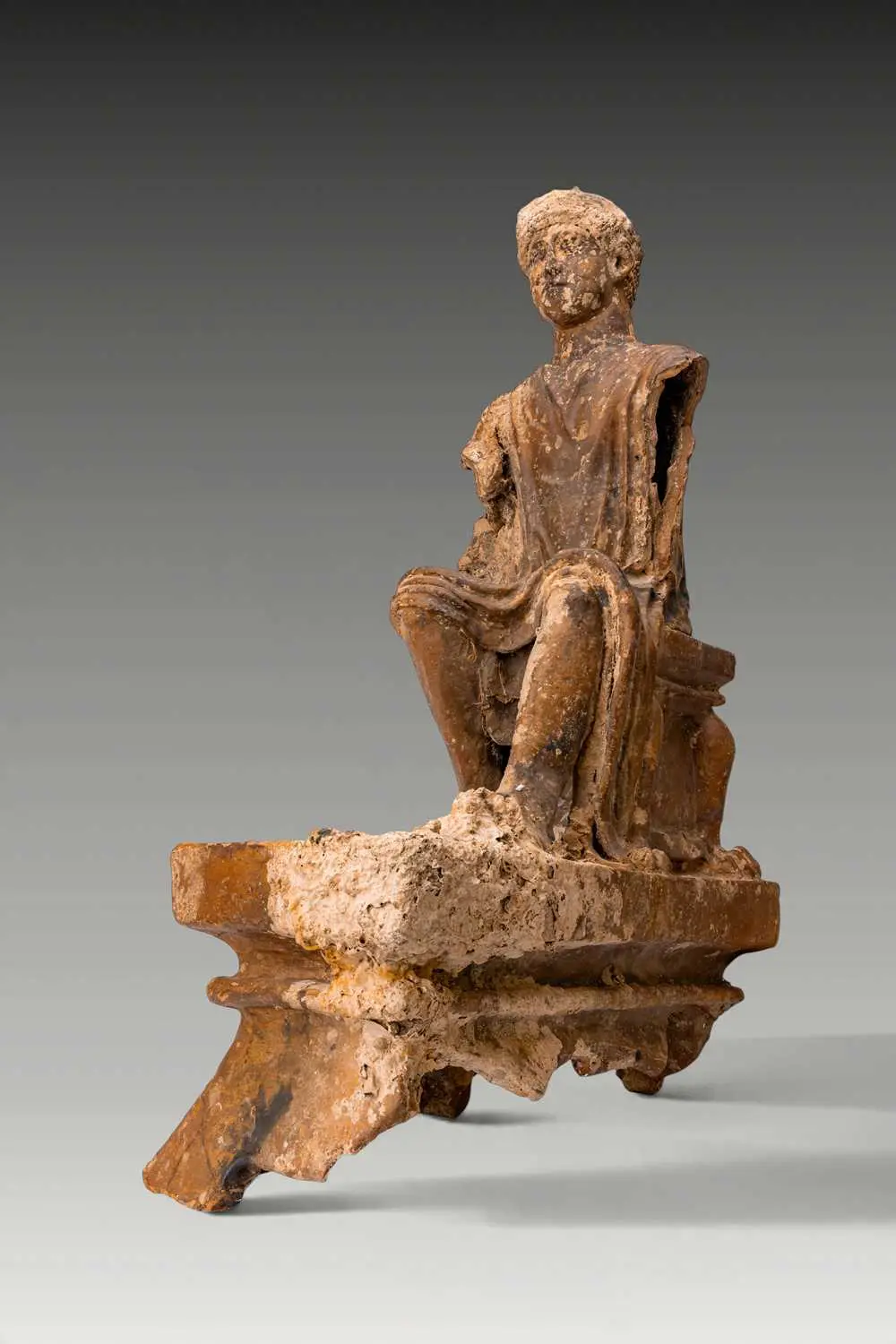 PHOENICIAN TERRACOTTA FIGURE OF A SEATED YOUTH