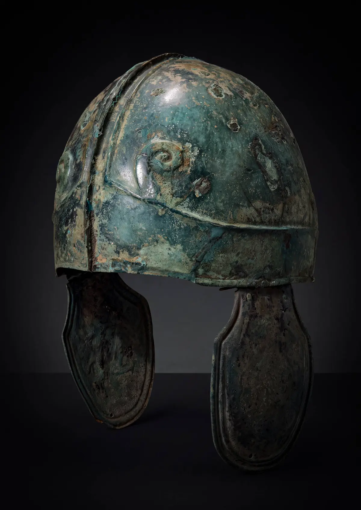 GREEK CHALCIDIAN BRONZE HELMET WITH ZEUS AMMON HORNS AND CHEEKPIECES