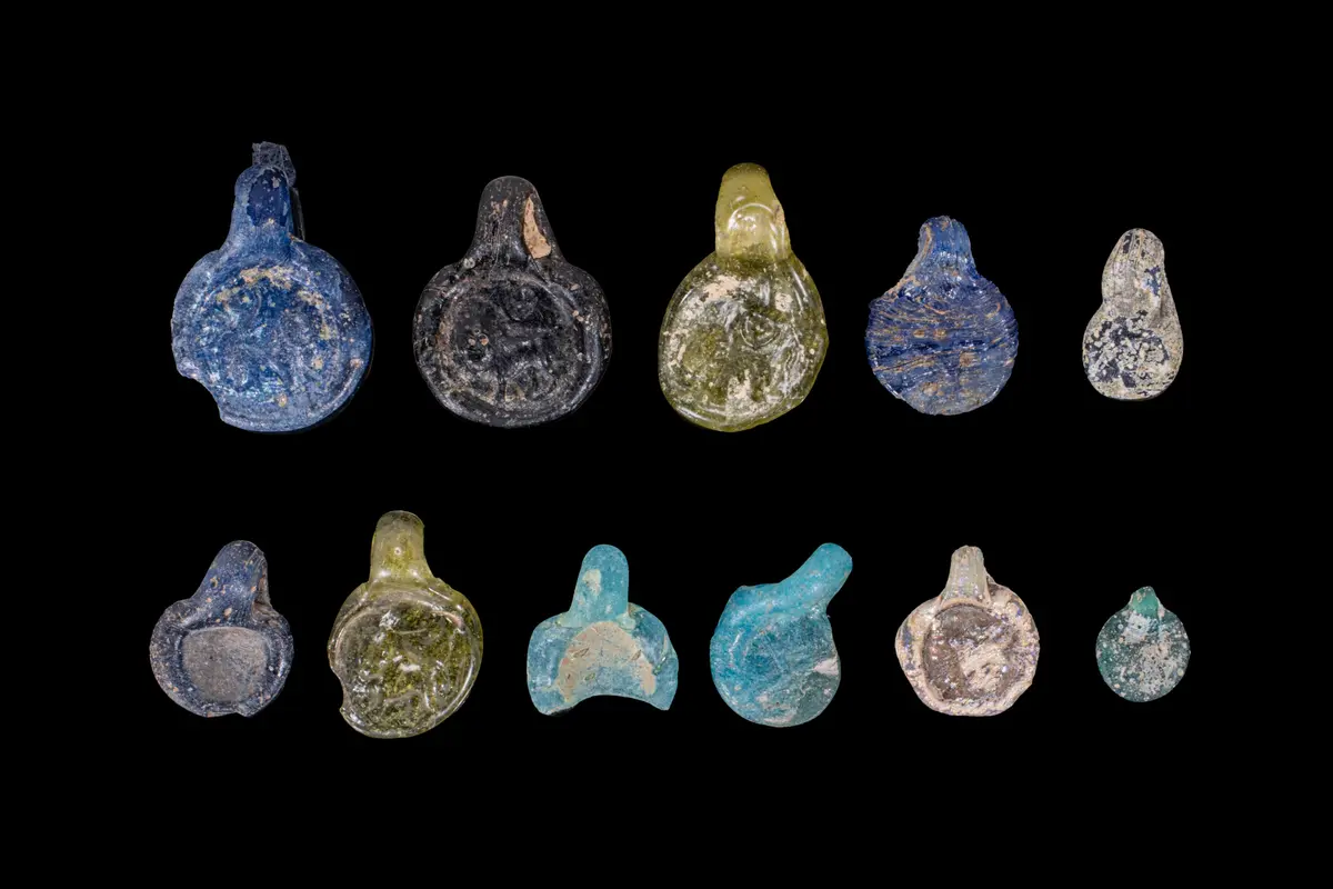 COLLECTION OF ROMAN GLASS STAMPED PENDANTS
