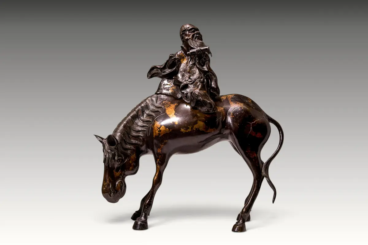 CHINESE PARCEL-GILT BRONZE FIGURE OF A RIDING SCHOLAR