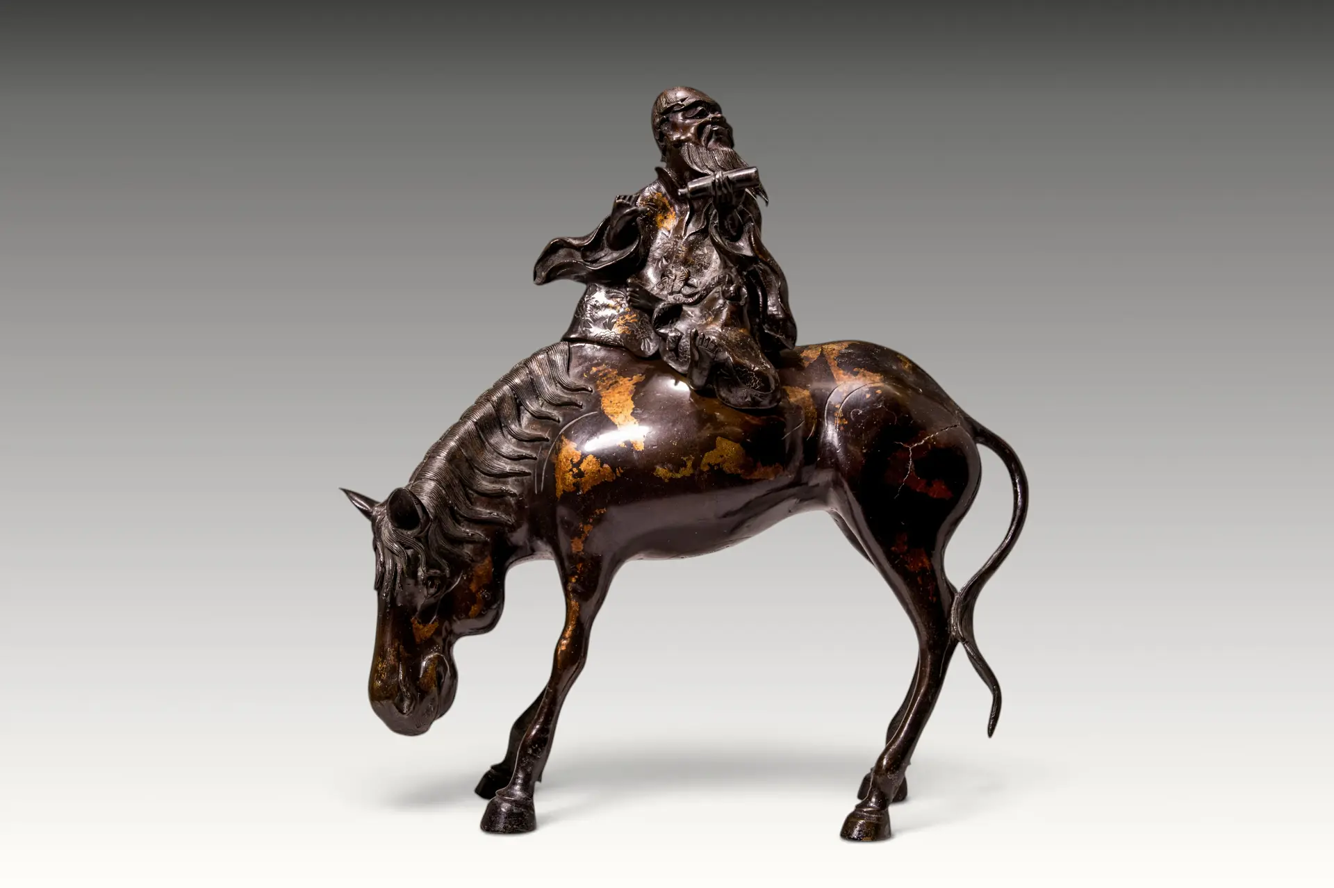 CHINESE PARCEL-GILT BRONZE FIGURE OF A RIDING SCHOLAR