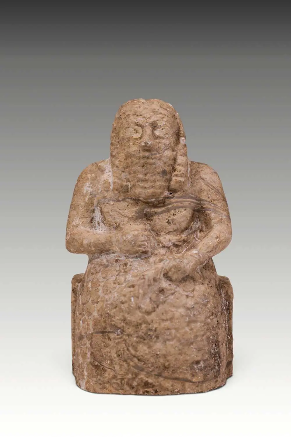 SUMERIAN MARBLE FIGURINE OF A SEATED PRIEST WITH INLAID EYES