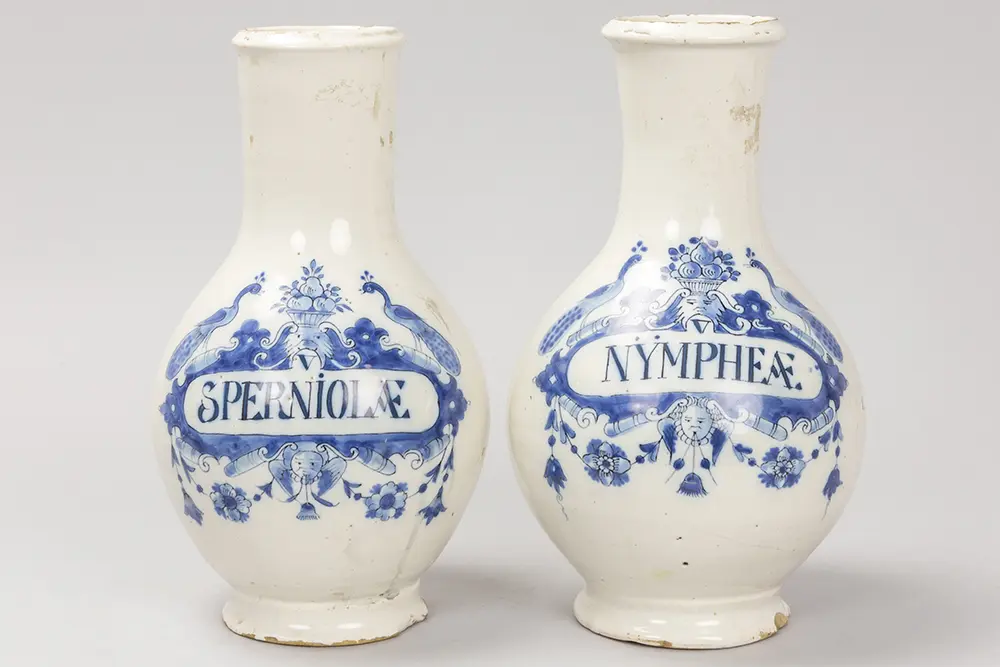Twee achttiende eeuwse apothekersflessen in faience van Delft met