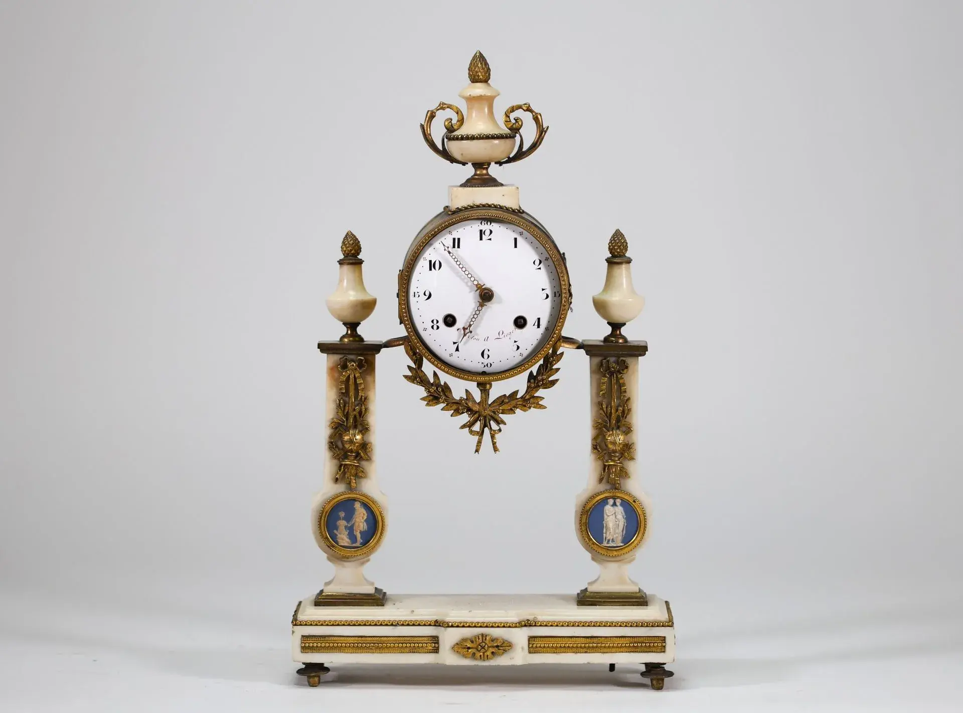 A white marble mantel clock resting on a rectangular base ad - Lot 218