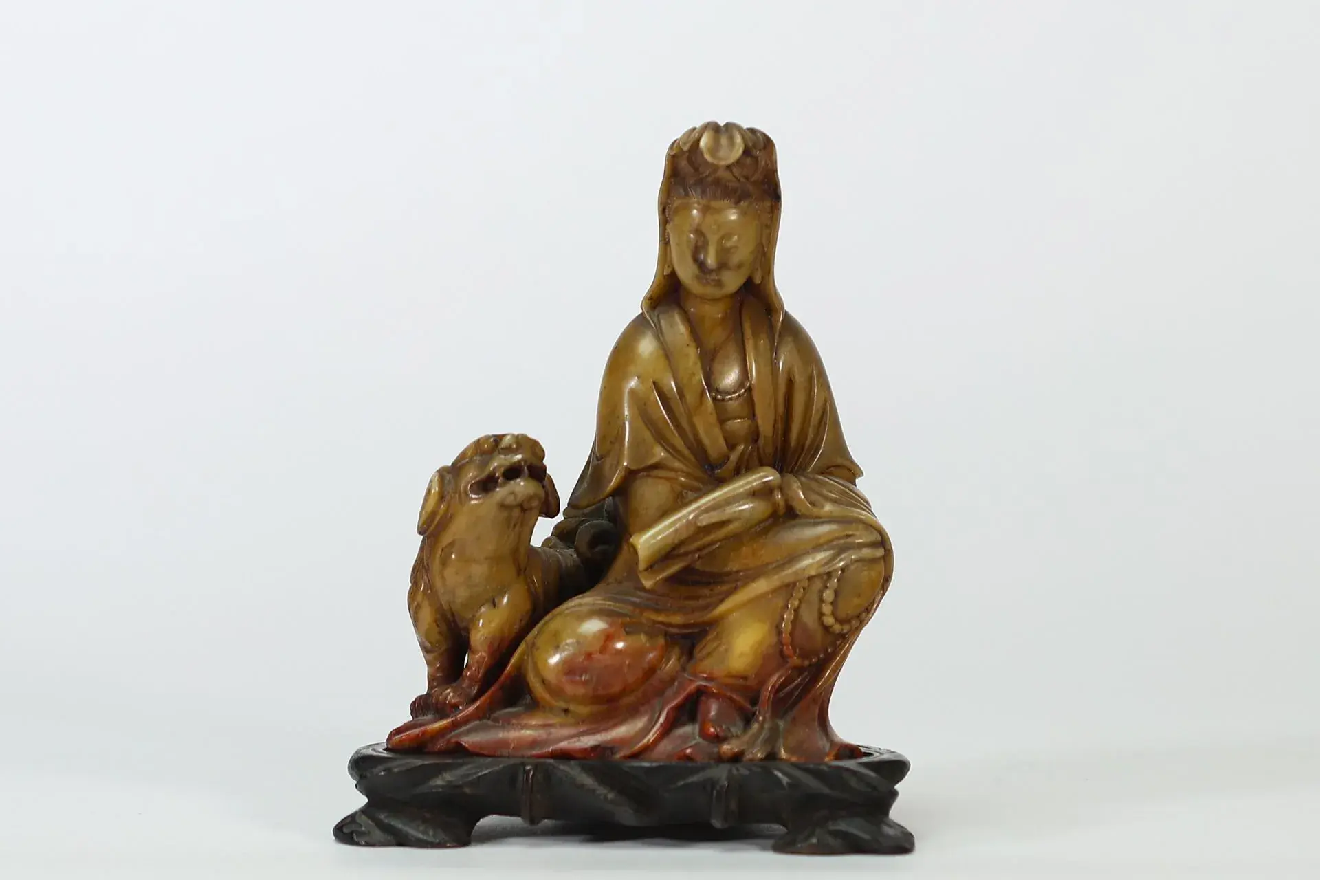 CHINA — A honey- and reddish-brown stone sculpture depicting - Lot 38