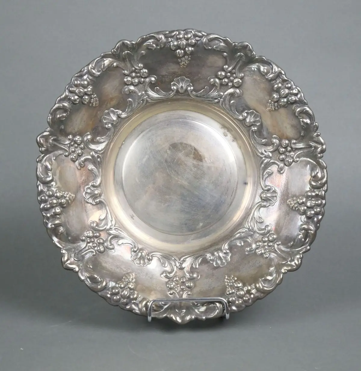 A circular silver plated metal bowl with rich chiseled and r - Lot 132