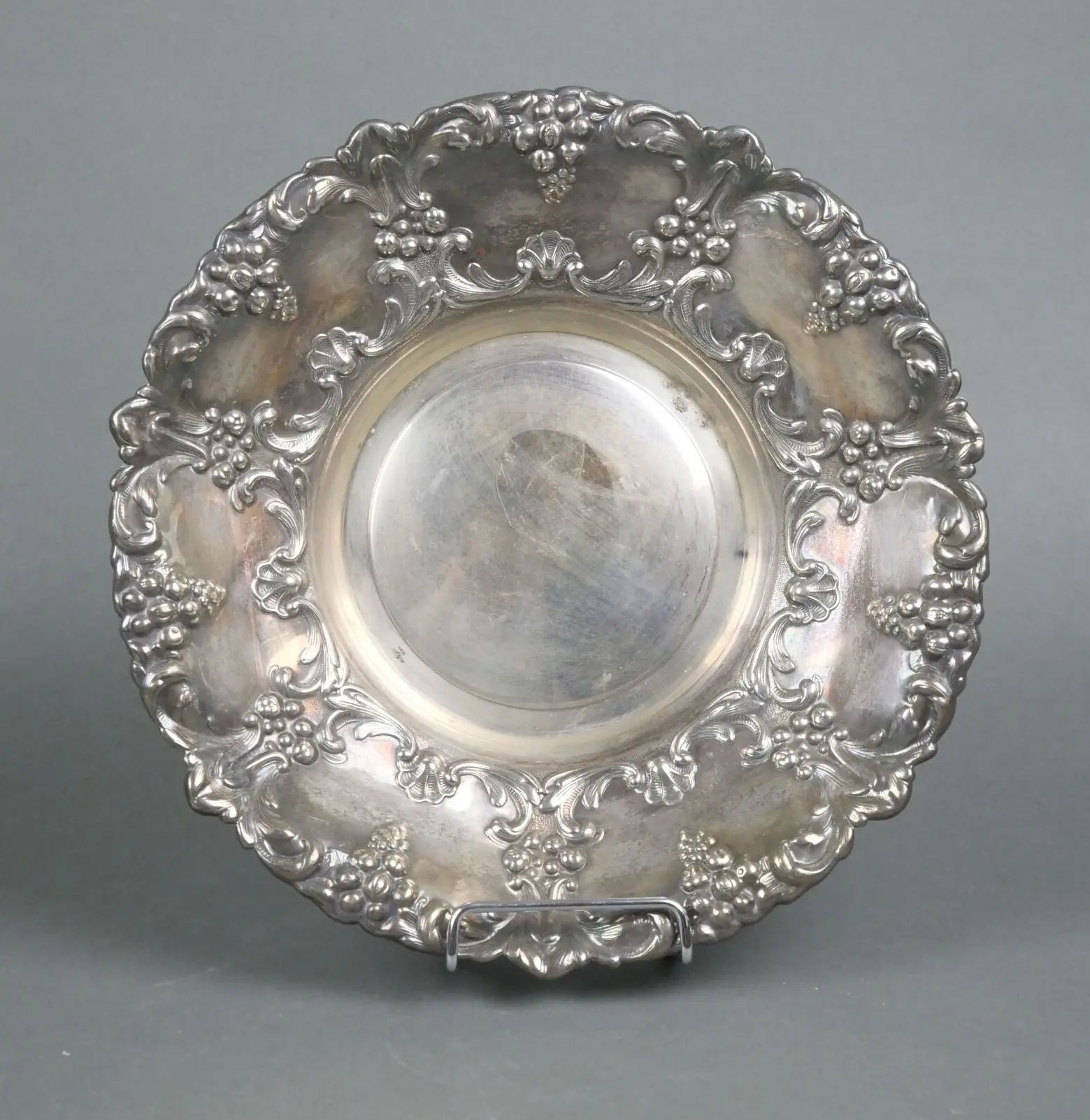 A circular silver plated metal bowl with rich chiseled and r - Lot 132
