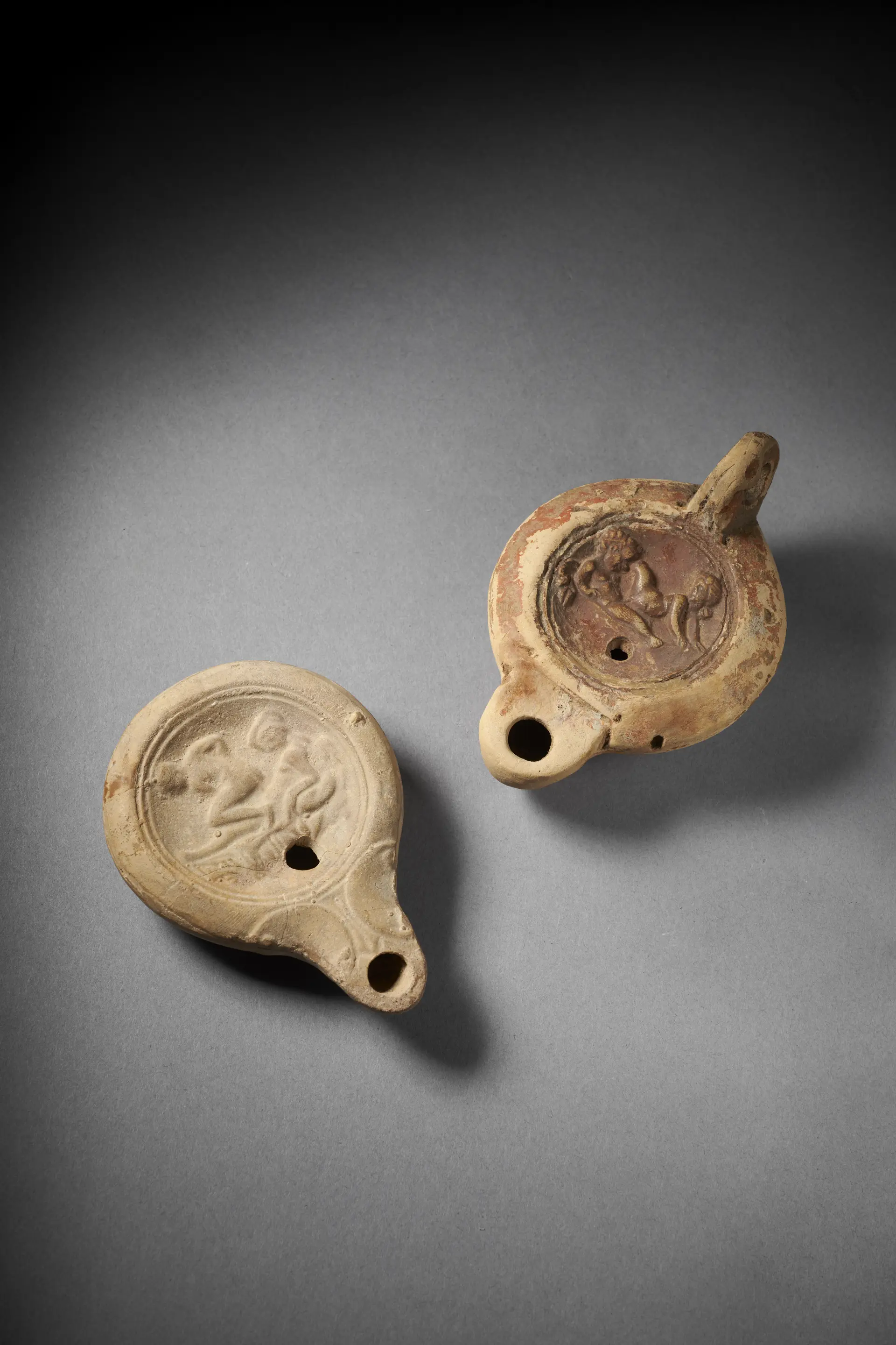 Two Roman terracotta oil lamps with Erotic scene